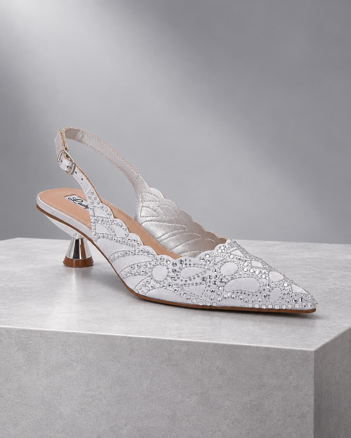 Kaite Silver crystal slingback shoe on a cool silver studio plinth